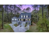 Charming two-story home with a double garage and welcoming front porch nestled among tall trees at 2856 Claybrook St, Johns Island, SC 29455