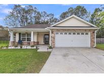 Charming single-story home featuring a brick facade and a well-manicured front yard with a two car garage at 311 Old Stone Ct, Moncks Corner, SC 29461