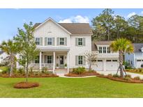 Charming two-story white home featuring a welcoming front porch and a well-manicured lawn at 3873 Newhall St, Mount Pleasant, SC 29466