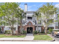 Charming multi-story condo building with brick accents, lush landscaping, and mature trees offering a welcoming entrance at 45 Sycamore Ave # 116, Charleston, SC 29407