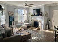 Bright living room featuring a fireplace, ceiling fan and natural light from the large window at 45 Sycamore Ave # 536, Charleston, SC 29407