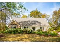 Charming single-story home with a lush landscaped yard and blooming azaleas at 630 Cain Dr, Mount Pleasant, SC 29464