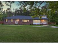 Charming brick home with a well-manicured lawn and mature trees creating a serene outdoor space at 1085 Russellville Rd, Saint Stephen, SC 29479