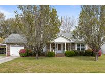 Charming brick home with a manicured lawn, flowering bushes, and inviting front porch at 1144 Island View Dr, Mount Pleasant, SC 29464