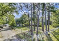 Landscaped yard featuring a white home, a privacy fence, and a canopy at 130 Oak Crest Dr, Moncks Corner, SC 29461
