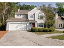 Charming two-story home with a well-maintained lawn, two car garage, and inviting red front door at 1400 Harbor Mist Ct, Charleston, SC 29492