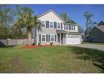 Charming two-story home featuring a manicured lawn, two car garage, and beautiful landscaping at 1909 Royal Empress Ct, Charleston, SC 29414