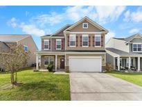 Charming two-story home featuring a two-car garage and beautifully landscaped front yard at 320 Silverleaf Ln, Moncks Corner, SC 29461