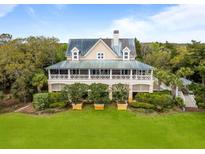 Beautiful exterior view of home with a metal roof, spacious porch, lush landscaping and mature trees at 377 Lofton Ct, McClellanville, SC 29458