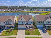 A beautiful aerial view of this two-story home with a lake view and well-manicured lawn at 400 Dunlin Dr, Summerville, SC 29486