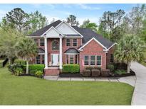 Stately two-story red brick home with manicured lawn, mature trees, and elegant architectural details at 4204 Magnolia Ct, North Charleston, SC 29420