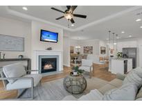 Inviting living room featuring a cozy fireplace, ceiling fan, and seamless flow to the dining area and kitchen at 614 Beach Way, Summerville, SC 29486