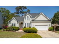 Charming two-story home features a manicured lawn, attached garage, and inviting curb appeal at 68 Oyster Point Row, Charleston, SC 29412