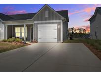 Charming home featuring a spacious driveway and a white garage door, set against a beautiful sunset at 832 Descartes St, Summerville, SC 29486