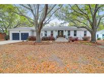 Charming brick home featuring a well-manicured front yard with mature trees at 935 Lansing Dr, Mount Pleasant, SC 29464