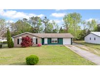 Charming single-story home with brick and siding, a well-manicured lawn, and a convenient attached garage at 1003 Mountain Pine Rd, Moncks Corner, SC 29461