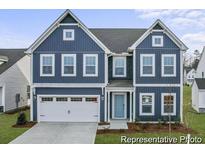 Charming two-story home featuring a blue exterior, a white garage door, and a well-manicured front lawn at 1005 Toland Dr # 44P, Saint George, SC 29477
