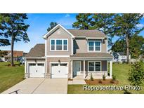 Charming two-story home with a manicured lawn, two car garage, and attractive curb appeal at 1007 Toland Dr # 45P, Saint George, SC 29477
