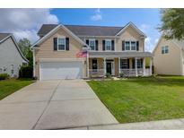 Inviting two-story home featuring a charming front porch and a well-maintained lawn at 106 Gathering Island Rd, Summerville, SC 29485