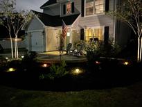 Charming two-story home featuring a front yard with landscaped lighting and comfortable seating area at 1414 N Sherwood Dr, Charleston, SC 29407