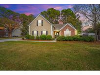 Charming two-story home featuring brick accents and a beautifully landscaped front yard at twilight at 177 Thousand Oaks Cir, Goose Creek, SC 29445