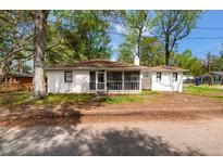 Charming single-story home with a screened-in front porch and lush greenery at 1778 Brockington Ave, Charleston, SC 29407