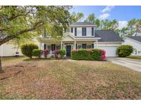 Charming two-story home with landscaped yard and inviting curb appeal on a sunny day at 2019 Azalee Ln, Summerville, SC 29483