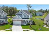 Charming two-story home featuring a well-manicured lawn, a pond view, and a classic architectural style at 215 Center Hill Ct, Summerville, SC 29485