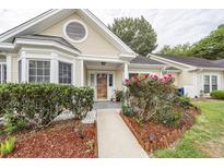 Charming one-story home featuring a well-manicured yard, covered porch, and a welcoming entrance at 2441 Hansard Dr, North Charleston, SC 29406