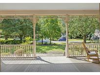 Inviting covered front porch with rocking chair overlooking the lush green front yard at 3168 Stanyarne Dr, Charleston, SC 29414
