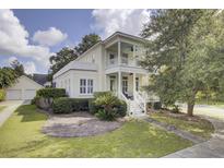 Charming two-story home featuring a double porch, manicured lawn, and lush landscaping creating a welcoming curb appeal at 3302 Porchview Pl, Johns Island, SC 29455