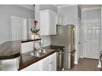 Galley kitchen boasts stainless steel appliances, wood countertops, and white cabinetry at 45 Sycamore Ave # 1327, Charleston, SC 29407