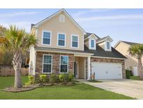 Charming two-story home featuring a stone and vinyl facade, attached garage, and a well-manicured lawn at 470 Gianna Ln, Goose Creek, SC 29445