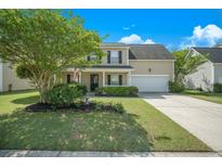 Charming two-story home featuring a well-manicured lawn, lush landscaping, and inviting front porch at 529 Beverly Dr, Summerville, SC 29485