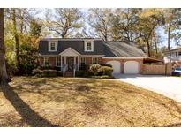 Charming brick home with a welcoming front porch, dormer windows, mature trees and a two-car attached garage at 643 Edmonds Dr, Charleston, SC 29412