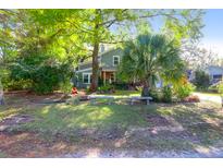 Charming home with a well-maintained front yard, mature trees, and stone benches at 683 Edmonds Dr, Charleston, SC 29412