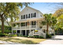 Charming two-story home with a welcoming porch, lush landscaping, and classic coastal architecture at 825 Marsh Grove Ave, Mount Pleasant, SC 29464