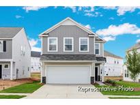 Charming two-story home with gray siding, a two-car garage, and a well-manicured lawn on a sunny day at 1008 Drakeford St # 4P, Saint George, SC 29477
