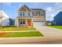 Charming two-story home boasts a well-manicured lawn, two-car garage and inviting orange front door at 1017 Marsh Harrier Dr # Cc3-3-3, Ravenel, SC 29470