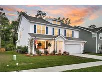 Beautiful two-story home with white siding, blue shutters, and an inviting front porch at sunset at 119 Loon Dr, Summerville, SC 29483