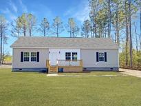 Charming single-story home with neutral siding, a well-manicured lawn, and a cozy front porch at 121 Dotson St, Harleyville, SC 29448
