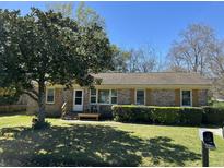 Charming brick home with well-maintained landscaping and a welcoming front porch at 122 Gator Dr, Goose Creek, SC 29445