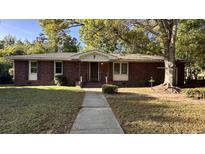 Charming single-story brick home with a well-maintained lawn and inviting front entrance at 1328 White Dr, Charleston, SC 29407