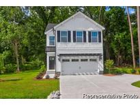 Charming two-story home featuring white siding, black shutters, and an attached garage, nestled on a lush green lawn at 229 Night Heron St # 602, Summerville, SC 29486