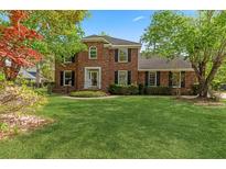 Charming two-story brick home featuring a well-manicured lawn and beautiful landscaping at 3176 Hagerty Dr, Charleston, SC 29414
