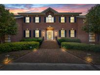 Stately two-story red brick home with symmetrical design, black shutters, and meticulously maintained landscaping at 4029 Gift Blvd, Johns Island, SC 29455