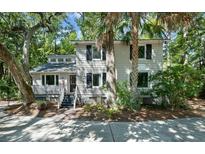 Exterior featuring a well-maintained home surrounded by mature trees and lush landscaping at 597 Oyster Rake Dr, Kiawah Island, SC 29455