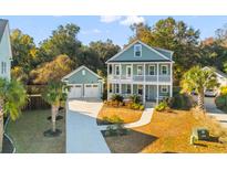 Beautiful two-story home featuring a front porch, a separate garage, and a well-maintained lawn at 1213 Captain Rivers Dr, Charleston, SC 29412