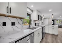 Modern kitchen features white cabinets, quartz countertops, stainless steel appliances, and a stylish backsplash at 1249 Sumner Ave, North Charleston, SC 29406