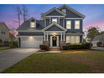 Charming two-story home with a well-manicured lawn, a welcoming front porch, and an attached two-car garage at 135 Marshside Dr, Summerville, SC 29485
